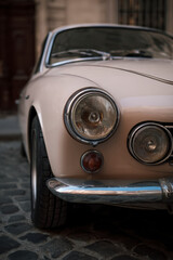 Vintage Charm: A classic car's headlamp and chrome bumper detail evoke timeless elegance and automotive history.