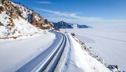 Scenic winter railway journey through snow-covered landscapes with mountain vistas and clear blue