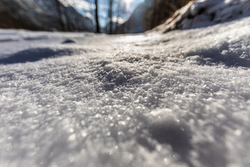 vista panoramica macro e di un terreno naturale di montagna coperto dalla neve bianca, illuminata...
