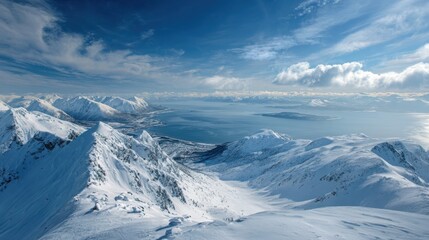 Obraz premium Majestic snow covered mountain range under a vast blue sky with dramatic clouds