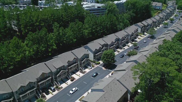 Modern row of multifamily townhouses, in modern architectural design with distinct rooflines and facades. Row or detached houses in suburb, Atlanta. Aerial view.