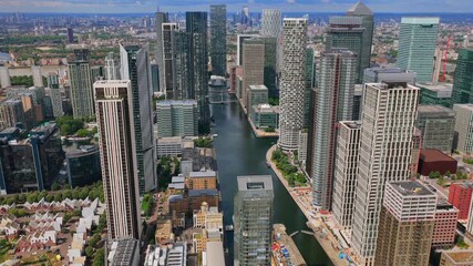 Aerial video reveal of the vertical cityscape showing Canary Wharf towers with Central London landmarks in the distance - Powered by Adobe