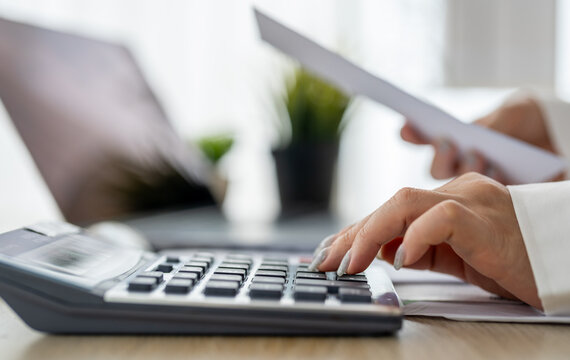 Human use calculator and calculate bills and paying bill, credit card, tax and vat, payment, concept of money management and business report with financial documents, financial accounting concept