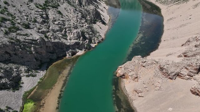 Zrmanja canyon river from Obrovac to river mouth aerial. Aerial shots of winding Zrmanja river cutting through deep canyon, lush spring colors and remote paths