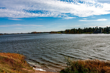 Serene Lakeside Scene with Gentle Waves and Autumn Landscape