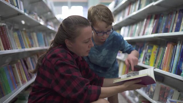 Little boy in glasses and his mother are choosing book - Powered by Adobe