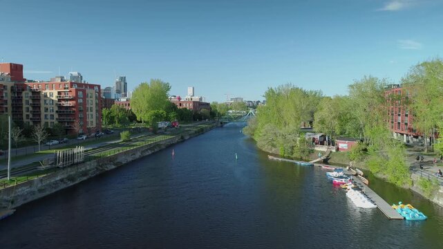Aerial view of the Lachine Canal in Montreal, Canada, showing the waterway, bridge, and city skyline. Illustrates urban landscape and recreational space.
