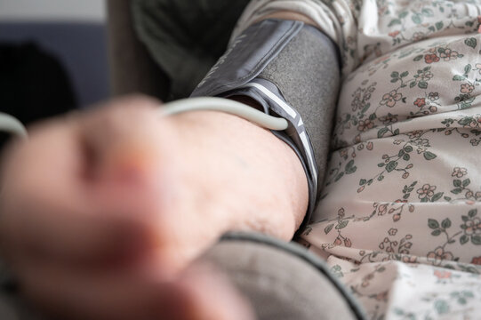 Senior woman checking blood pressure at home using a portable blood pressure monitor