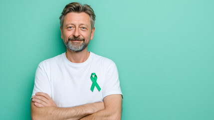 World Mental Health Day: Smiling man with a green awareness ribbon on a soft minimal background
