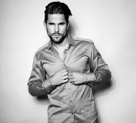 Handsome successful business man posing in suit and wearing wrist watch