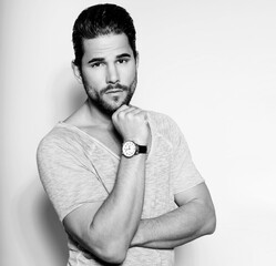Handsome young and successful business man posing with wirst watch in formal attire