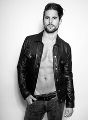 Handsome young and alethic man with six pack in leather jacket