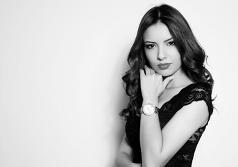 beautiful young woman with long black hair and wrist watch posing on white background