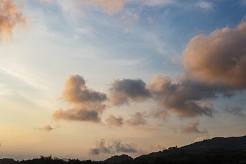 Sunset Clouds over Mountain Silhouette, beautiful bright clouds background, summer concept.