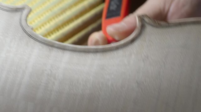 Experienced craftsman smoothing wooden violin surface, using precision knife while showcasing traditional luthier skills and detailed woodworking expertise - Powered by Adobe