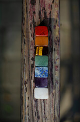 A set of colored stones in the seven chakras, for meditation on the wooden beam