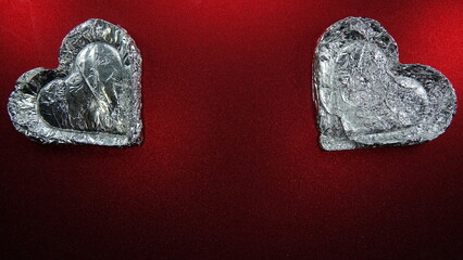 Srebrne serce na czerwonym brokatowym tle. Srebro i czerwień. Kształt serca. Miłość.  © tomo81