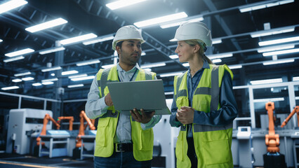 Portrait of Indian Male Engineer and Caucasian Female Professional Technician Standing In Factory...