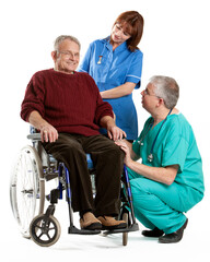 A medical team talks with a patient in a wheelchair. A doctor and a nurse are having a friendly...