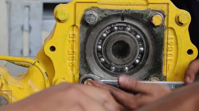 Close up mechanic hand installing O ring and cover transparent at Komatsu grader 8250 transmission.
