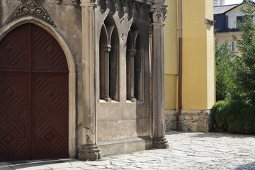 Architectural details of an ancient stone building with wooden doors and patterned windows in a...