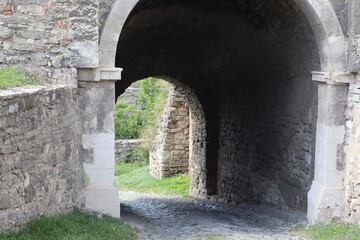 Exploring an ancient stone archway in a historical fort during early morning light in a picturesque...