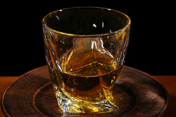 Whiskey in a glass with a complex shape. Selective focus.