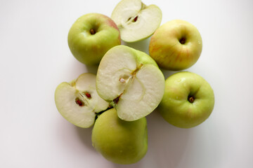 Fresh green apples. Whole and halved apples are placed together.
