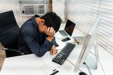 stressed asian businessman working in the office.	