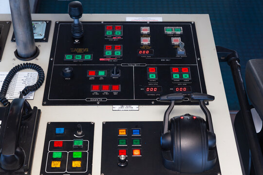 A control panel for a sea ship with various buttons, levers and switches. - Powered by Adobe