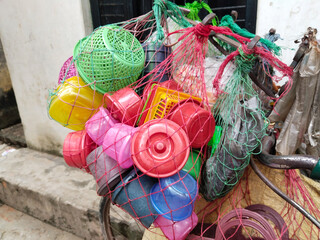 cycle vendor selling door to door in village. toy seller pedals his cycle, filled with colorful...
