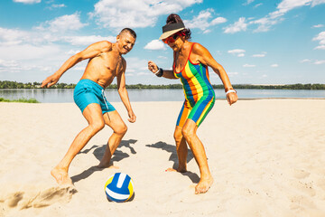 Senior man and woman playing beach volleyball on sunny day with bright blue sky. Concept of active aging, summer fun, and outdoor sports bringing energy and connection.