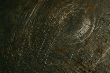 Fototapeta premium Close-up of textured dark wood with circular patterns and scratches