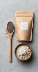 Wooden spoon with chia seeds, kraft bag of flour, and bowl of flour on a gray surface