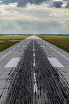 Spuren von Reifenabrieb landender Flugzeuge auf der Landebahn eines Flughafens im Detail