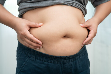 Asian woman use hand to squeeze fat belly big size overweight and obesity.
