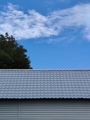 solar panels on roofblue sky white cirrus clouds tree roof corrugated sheet gray color metal house...