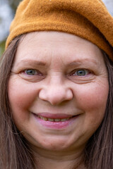 Happy senior woman enjoying fall season in warm beret, in autumn wearing cozy clothes in golden...
