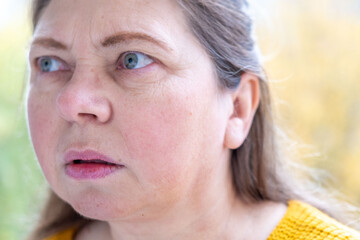 skeptical woman narrows eyes, expression filled with doubt in natural setting, raised eyebrow and...