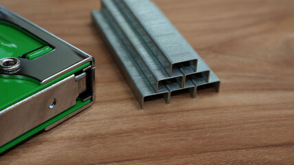 Gun tacker and metal staples on wooden surface