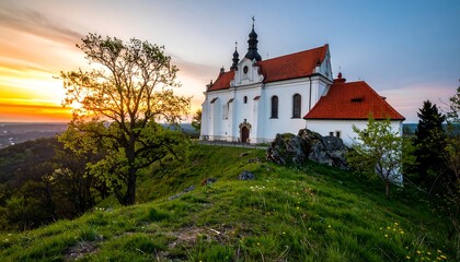 Fototapeta premium Hilltop church at sunset, vibrant colors, tree in foreground