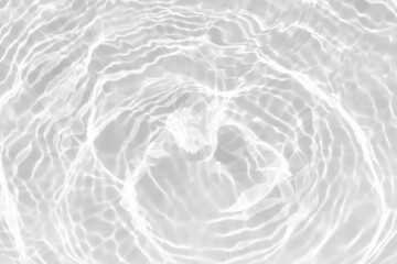White water with ripples on the surface. Defocus blurred transparent white colored clear calm water surface texture with splashes and bubbles. Water waves with shining pattern texture background.