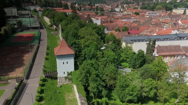Aerial summer view over Brasov old citadel walls under Tampa hill, featuring Turnul Artelor and Bastionul Tesatorilor with the Schei district in the background