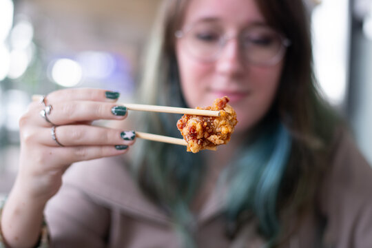 young woman holding kara age with chopsticks