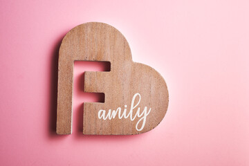   wood heart shaped with text family against pink background