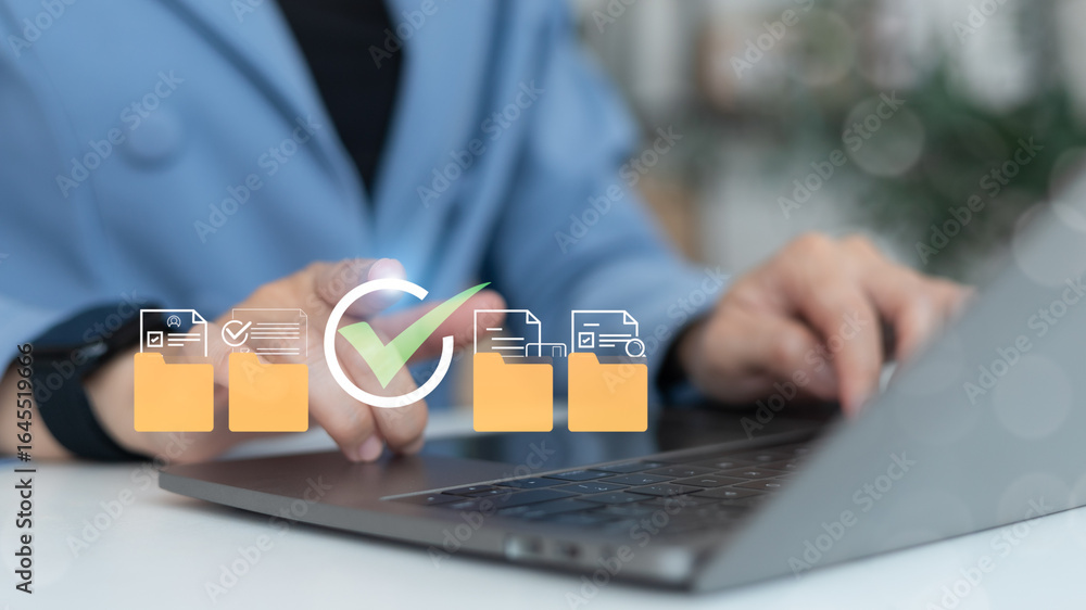 Poster businesswoman using a laptop to manage digital document folders with approval checkmark icons on a v