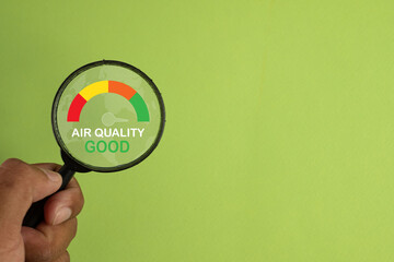 A magnifying glass shows a good level on an Air Quality Index (AQI) meter. A concept for clean air,...