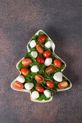 Italian Salad Caprese with cherry tomatoes, spinach and mozzarella cheese served in plate as...
