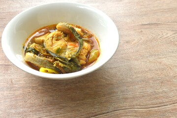 spicy chili boiled catfish with eggplant and basil in curry soup on bowl