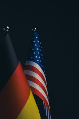 American and German flags on black background with copy space for text.